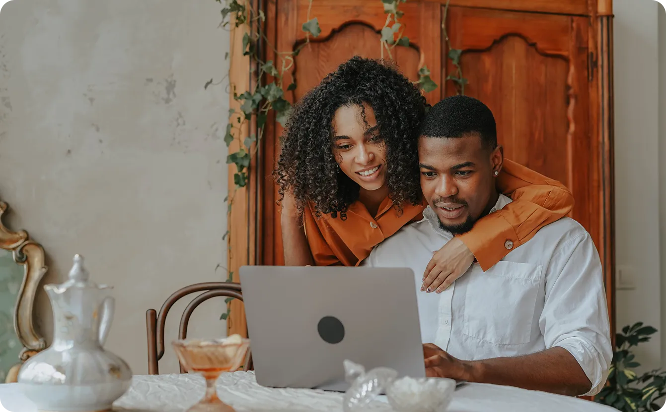 A couple reviewing wedding plans together on a laptop