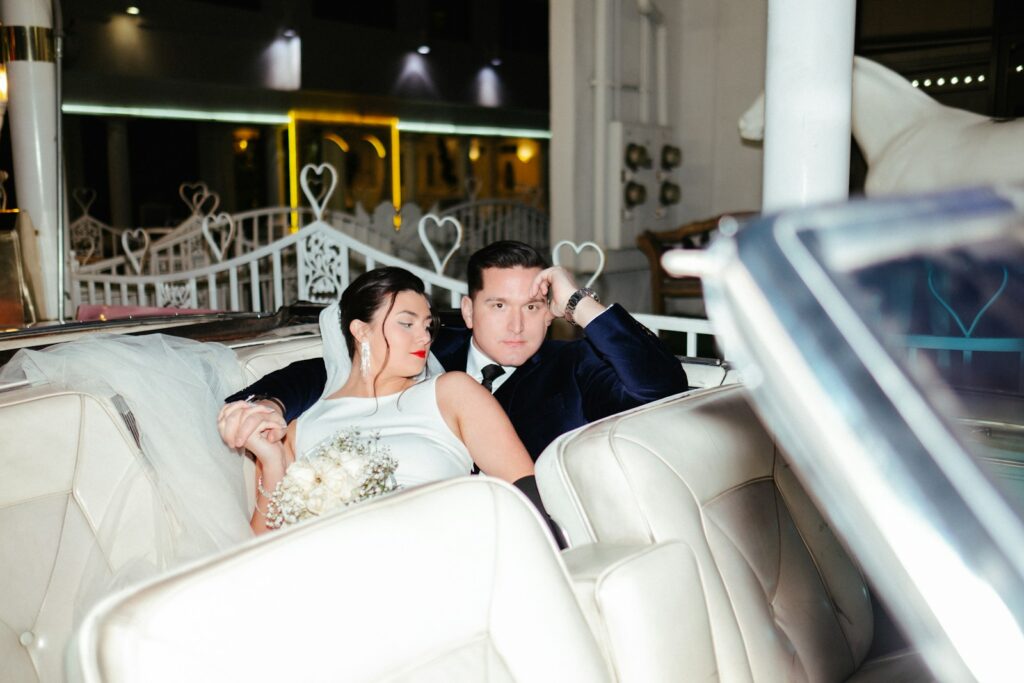 a bride and groom sitting on a white couch